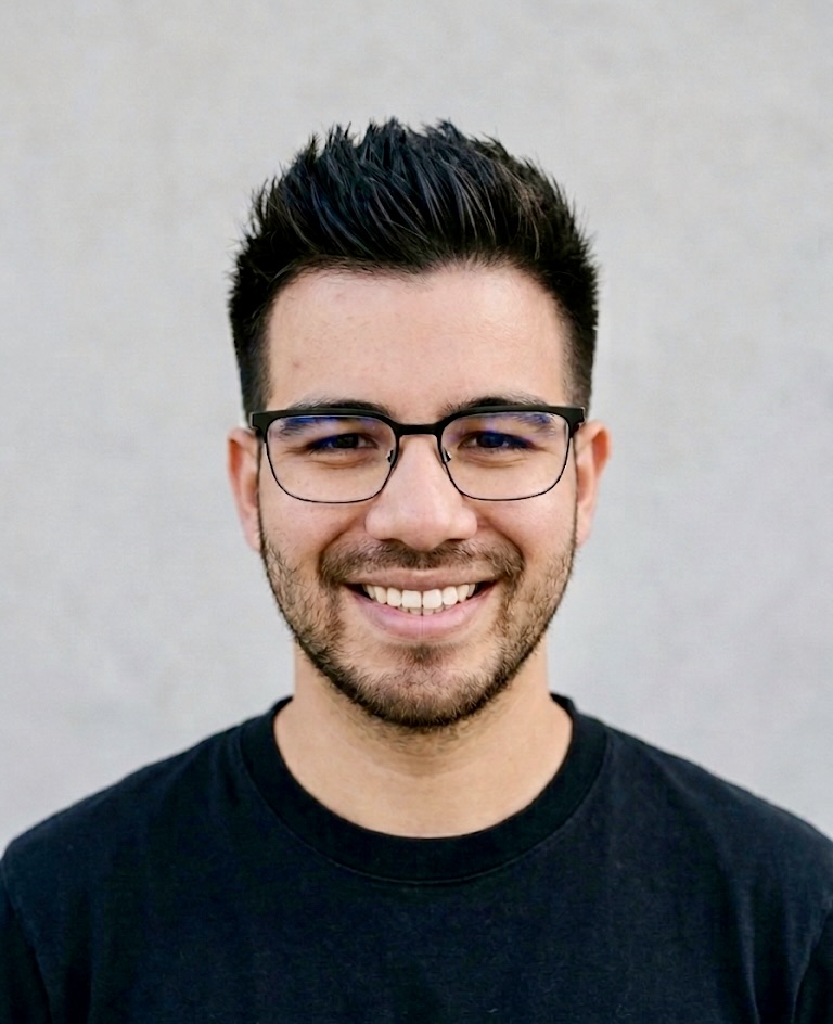 Jarrod Tran smiling in a direct portrait against a soft gray background